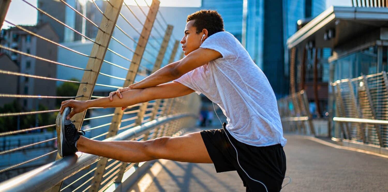 man stretching his hamstring before a run