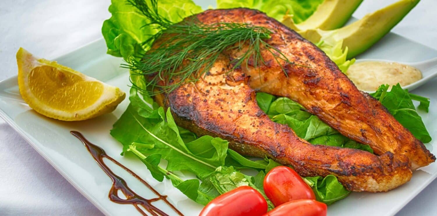 grilled salmon served with fresh vegetables and herbs