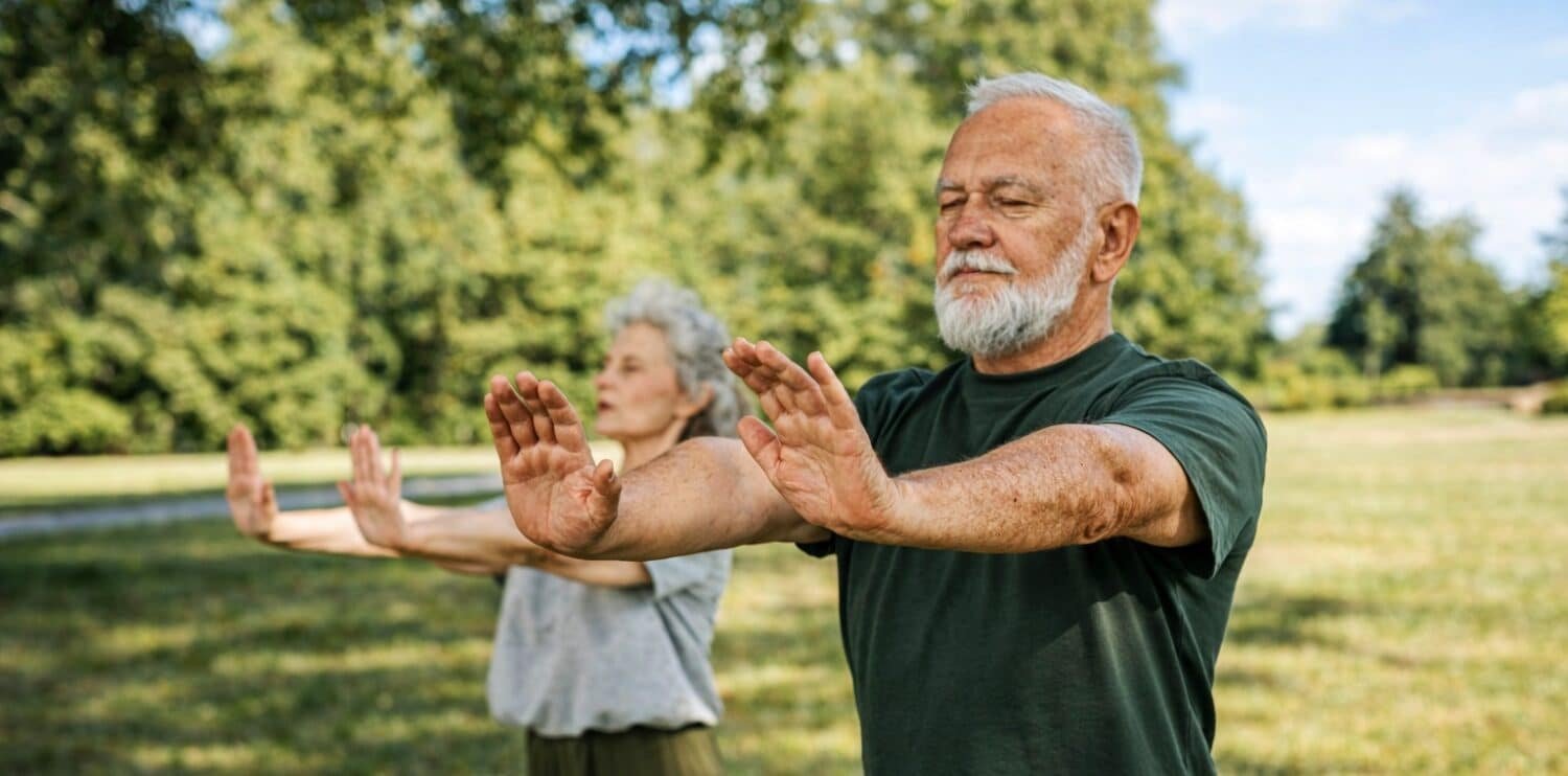 husband and wife practicing tai chi in the park