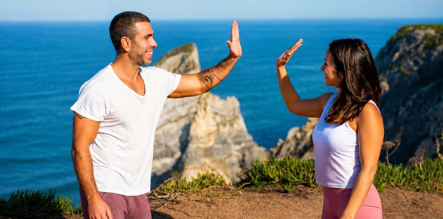 buddy workout - couple celebrate with a high-five after doing a costal hike