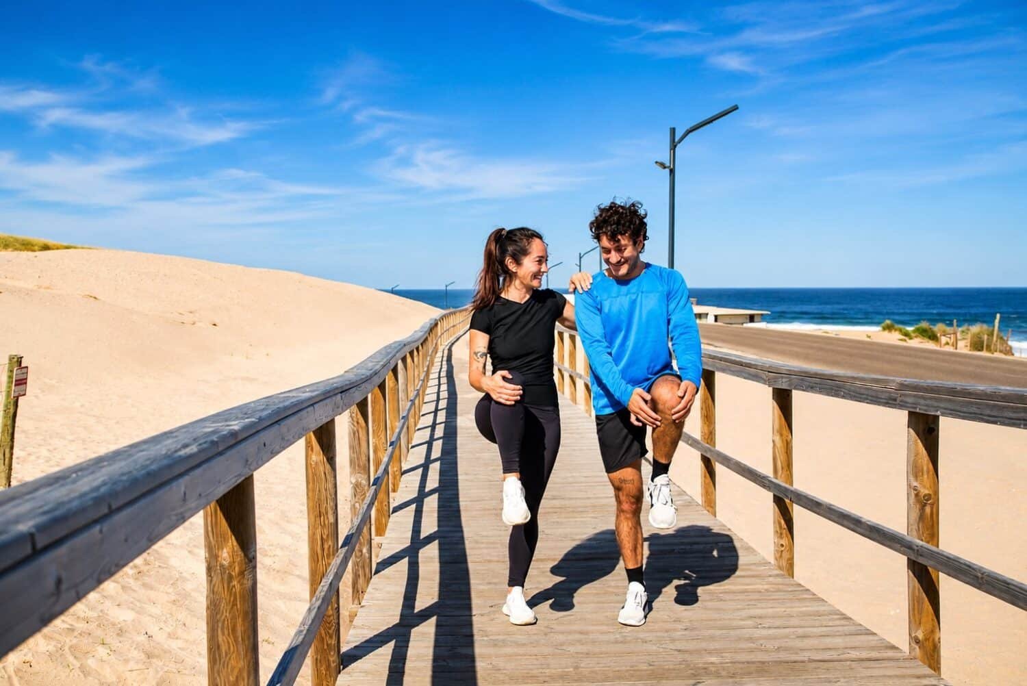 a couple stretching after a run near the beach