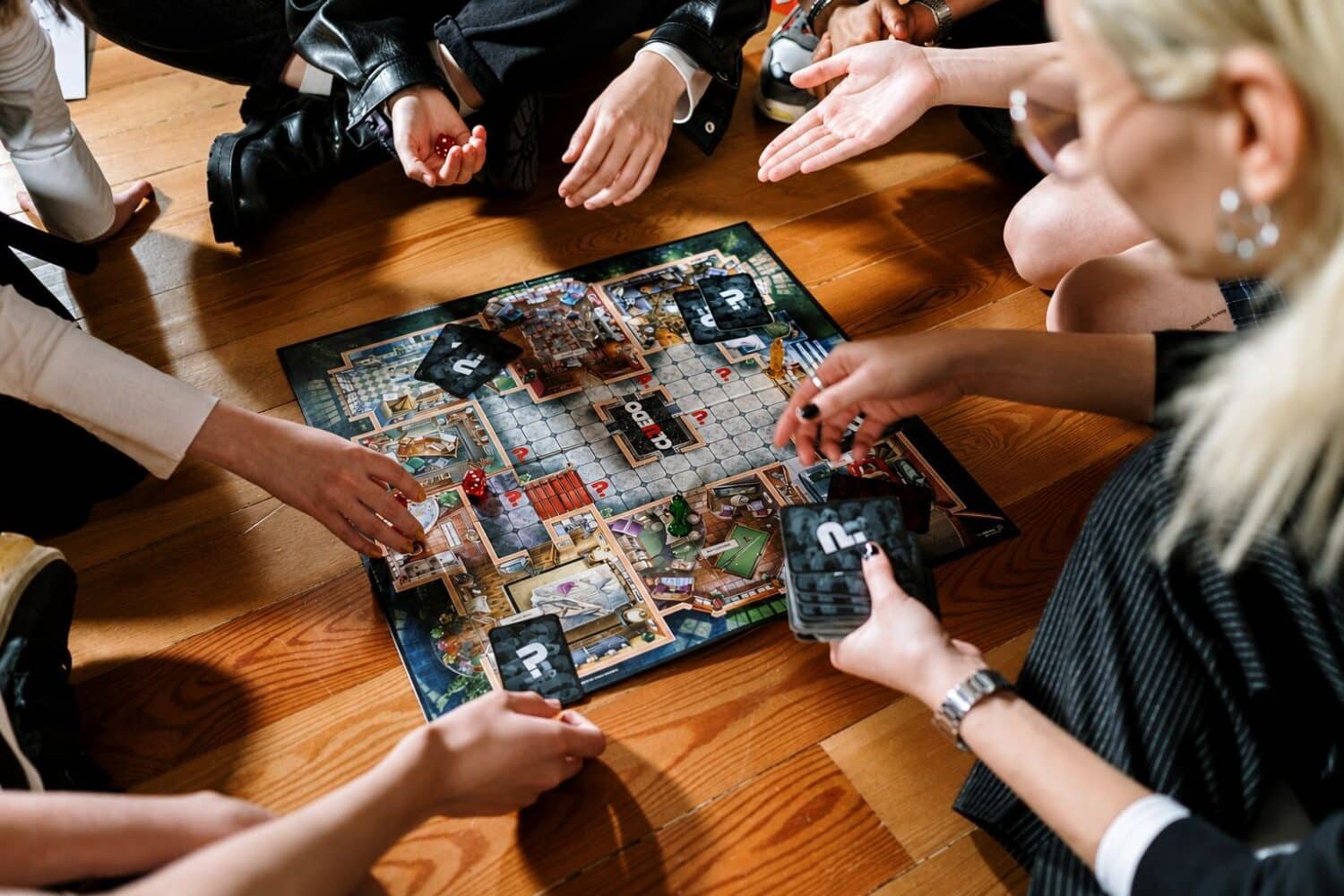a family enjoying phone-free time, playing Cluedo board game