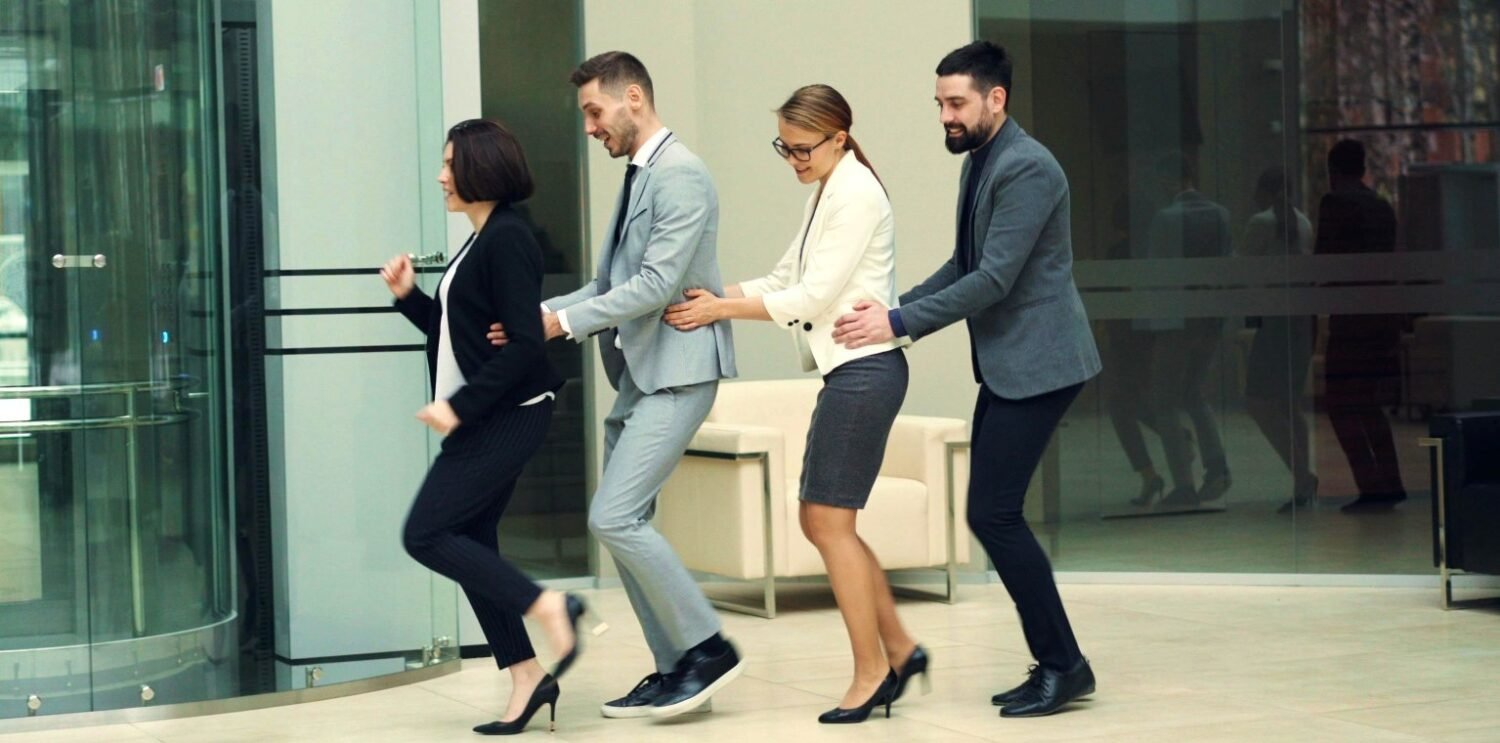 Colleagues dancing the conga round the office