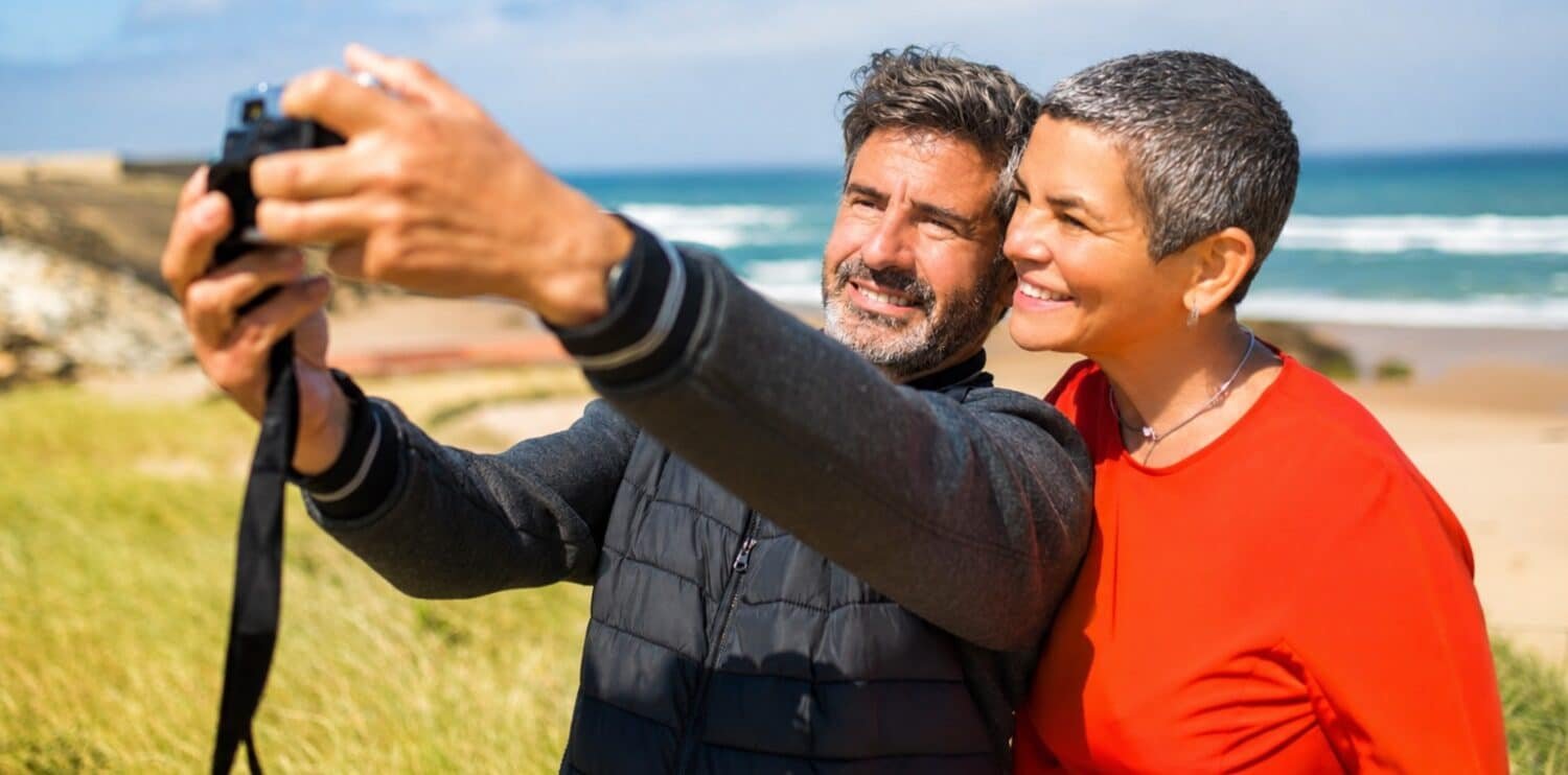 Middle age couple taking a selfie at the beach.